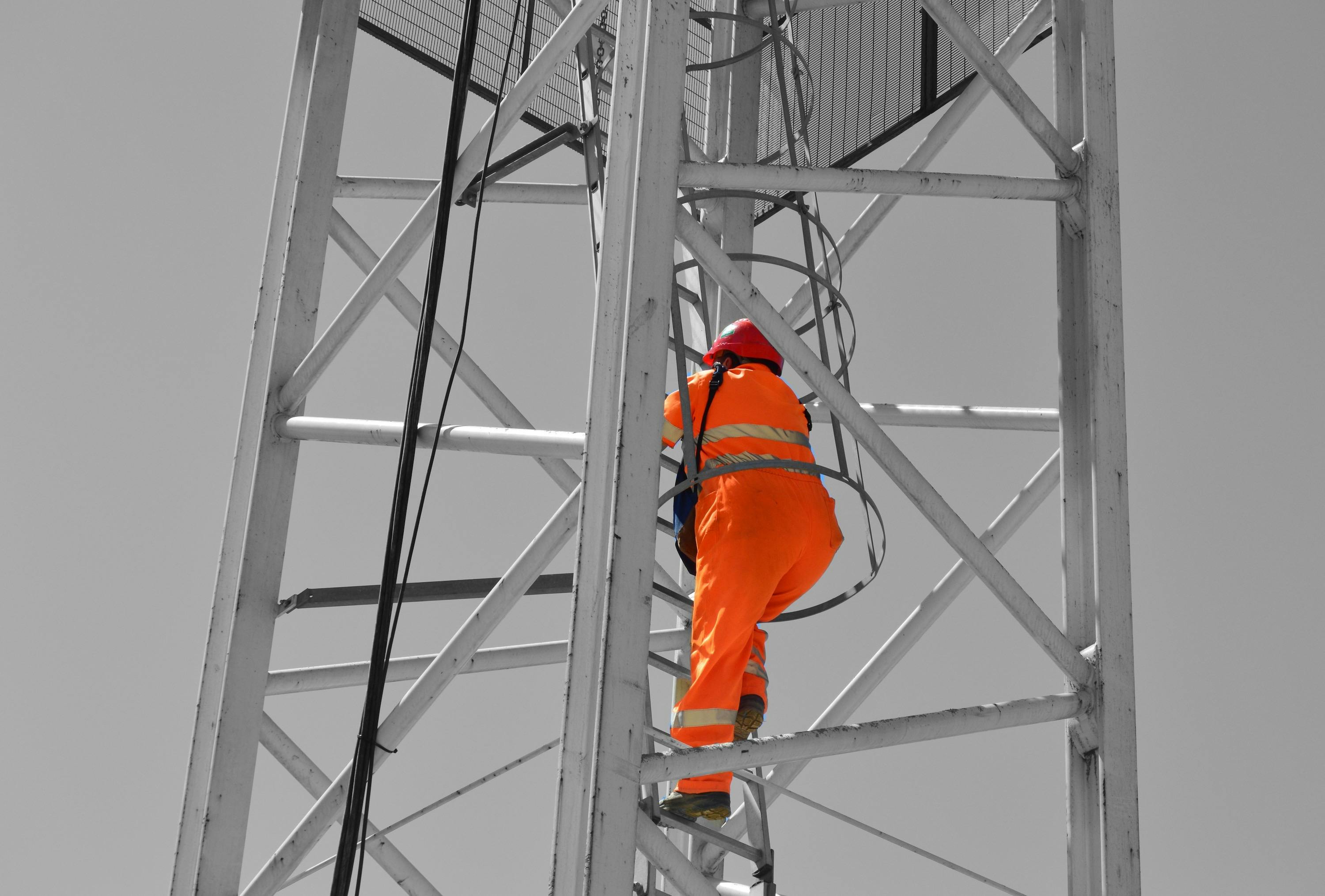 Crane operator climbing up ladder inside crane tower