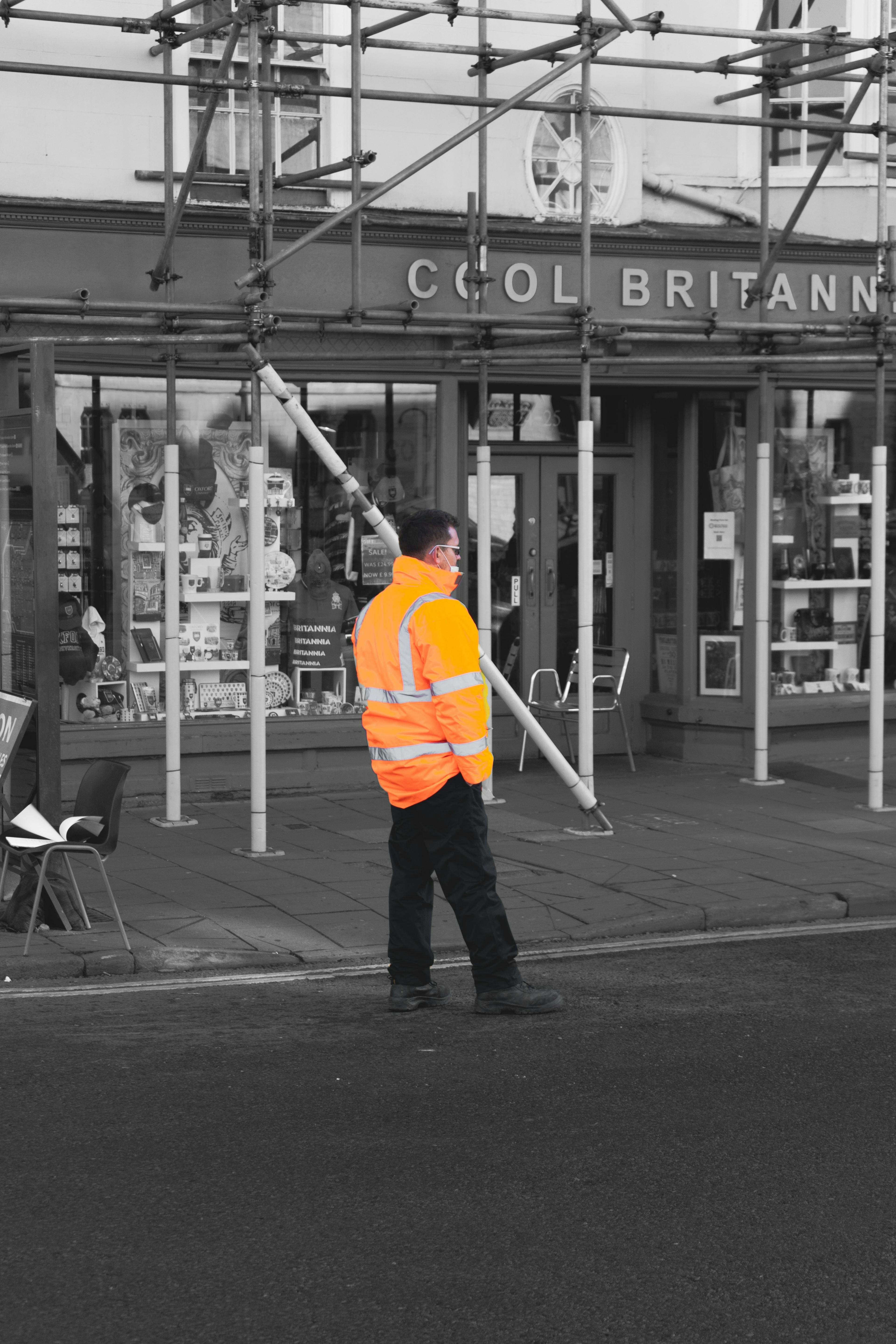 Male worker standing in a road wearing hi vis jacket with hands in pockets